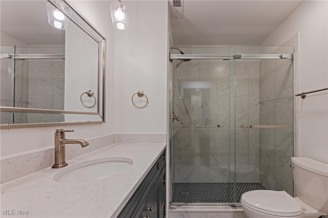 bathroom featuring vanity, toilet, and walk in shower