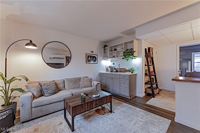 living room featuring an AC wall unit and hardwood / wood-style floors