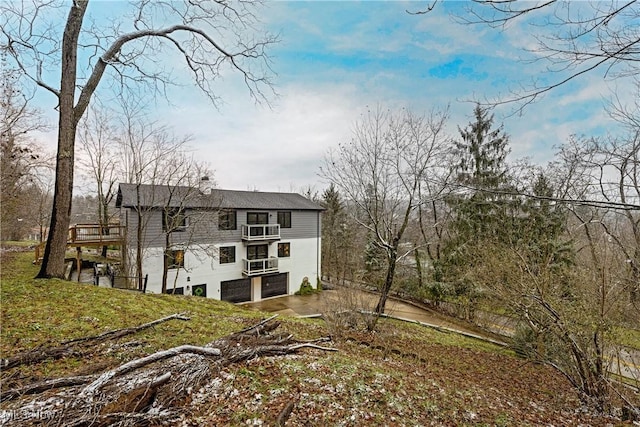 back of property with a lawn and a garage