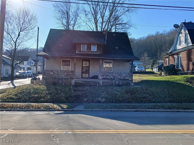 view of front of property with covered porch and a front yard