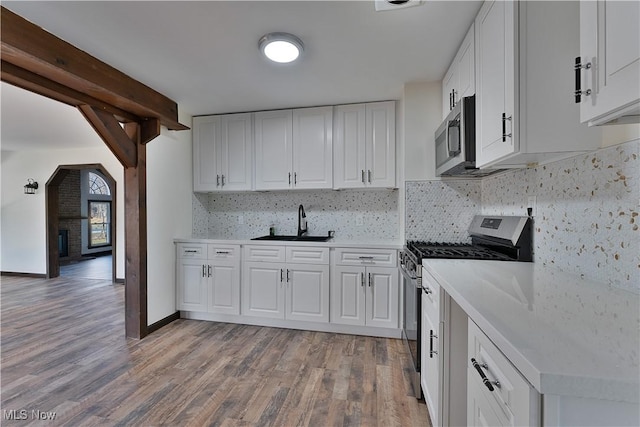 kitchen with white cabinets, stainless steel appliances, and light hardwood / wood-style floors