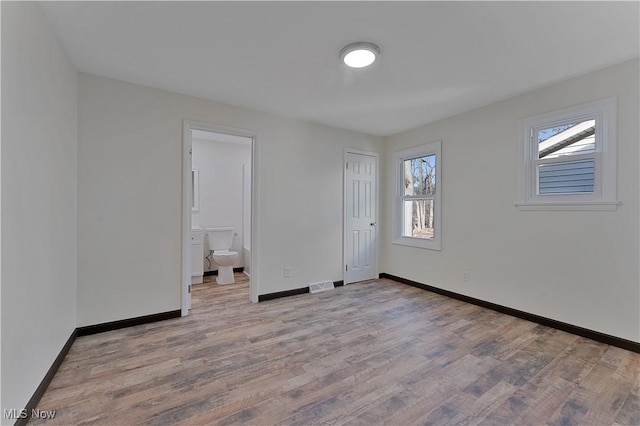 unfurnished room with light wood-type flooring and a wealth of natural light