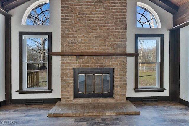 unfurnished living room featuring a fireplace, lofted ceiling, and dark wood-type flooring