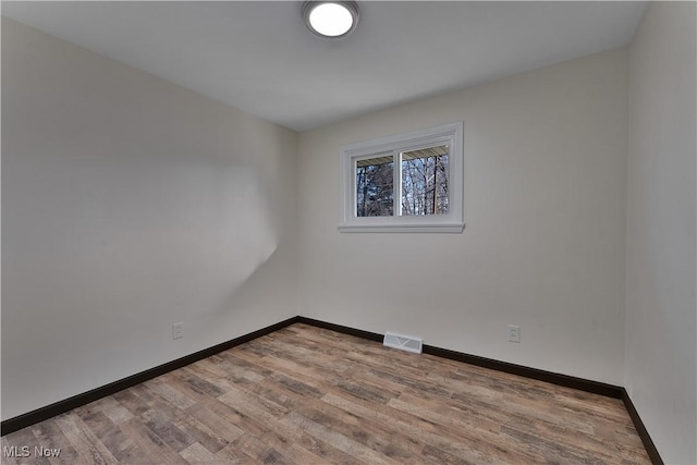 unfurnished room with hardwood / wood-style flooring