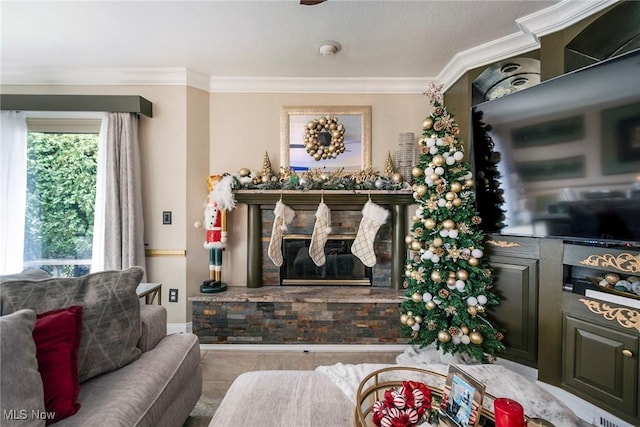 living room with a stone fireplace and ornamental molding