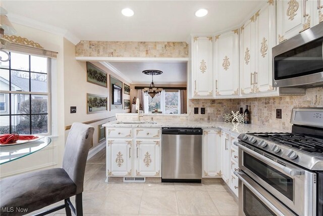 kitchen featuring pendant lighting, plenty of natural light, white cabinetry, and appliances with stainless steel finishes