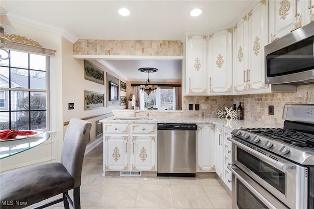 kitchen featuring ornamental molding, plenty of natural light, stainless steel appliances, and visible vents