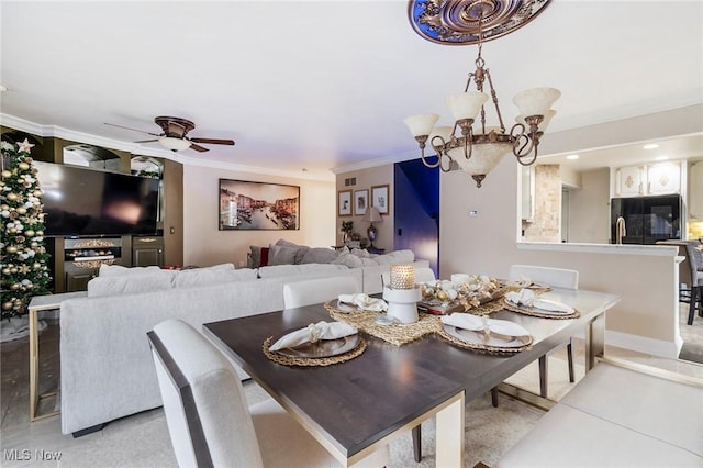 dining room with crown molding and ceiling fan with notable chandelier