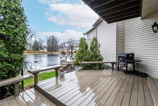 wooden deck featuring a water view and area for grilling