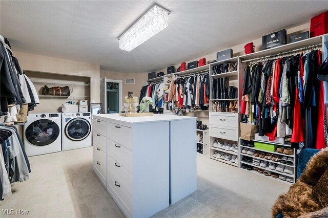 spacious closet with separate washer and dryer and light carpet