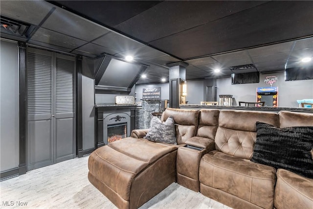 home theater room with a drop ceiling and a fireplace