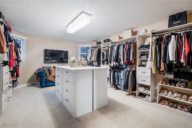 walk in closet featuring light colored carpet