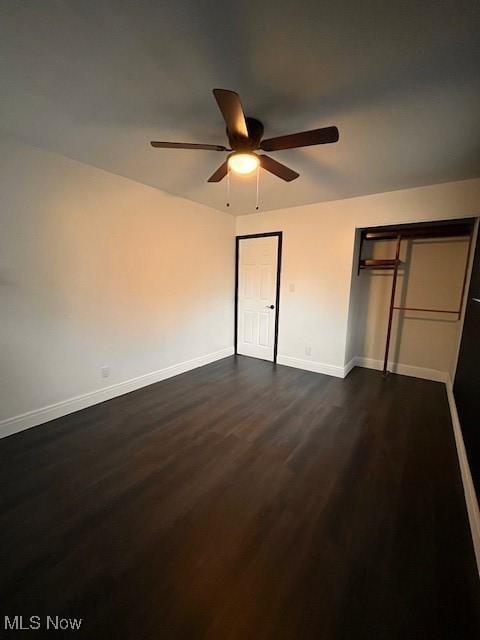 unfurnished bedroom with ceiling fan and dark wood-type flooring