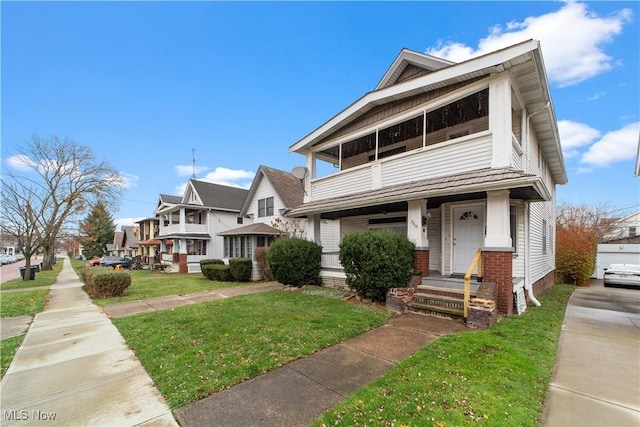 view of front of property with a balcony and a front lawn