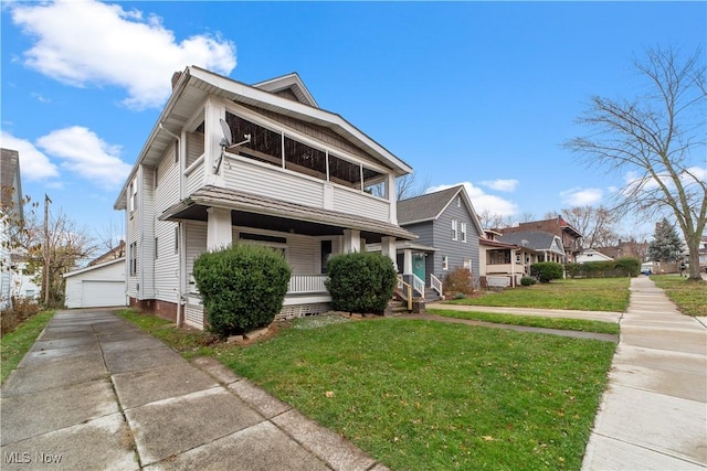 view of front of house with a porch, a garage, an outdoor structure, and a front yard