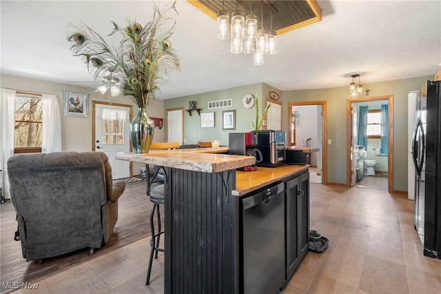 kitchen with a kitchen breakfast bar, a healthy amount of sunlight, decorative light fixtures, and appliances with stainless steel finishes