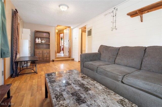 living room with hardwood / wood-style flooring and a textured ceiling