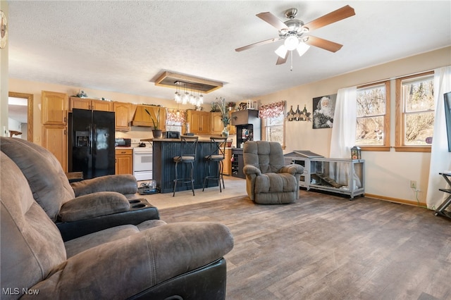 living room featuring hardwood / wood-style floors, a textured ceiling, and ceiling fan