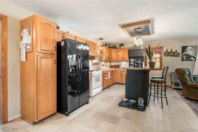 kitchen with a kitchen breakfast bar, black fridge, white range with electric stovetop, pendant lighting, and a textured ceiling