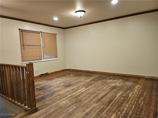 empty room with ornamental molding and hardwood / wood-style flooring