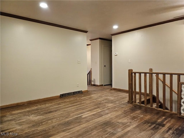 empty room featuring crown molding and dark hardwood / wood-style flooring