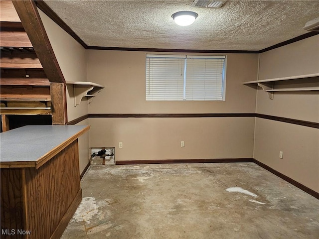 interior space featuring bar area, a textured ceiling, and ornamental molding