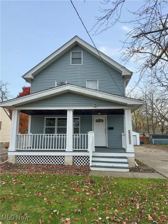 bungalow-style home featuring covered porch and a front lawn