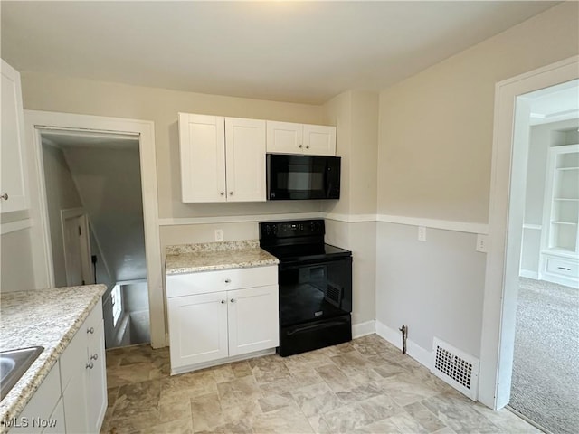 kitchen with light carpet, sink, white cabinets, and black appliances