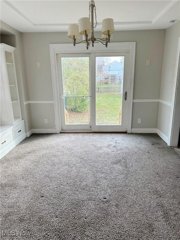 unfurnished room with carpet and a notable chandelier