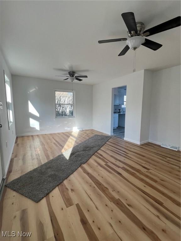 unfurnished living room with hardwood / wood-style floors and ceiling fan