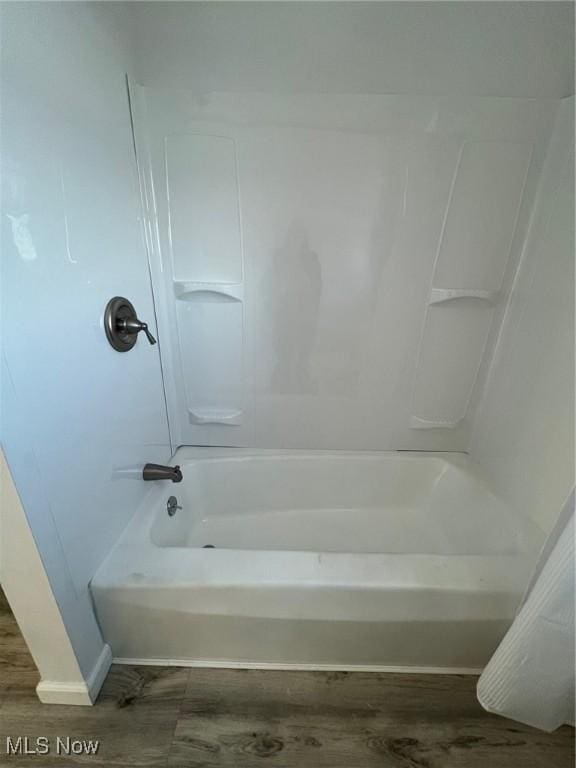 bathroom featuring  shower combination and hardwood / wood-style flooring