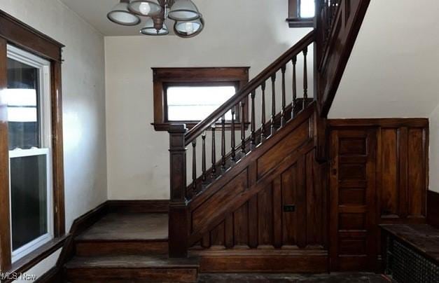 stairs with a chandelier and wood-type flooring