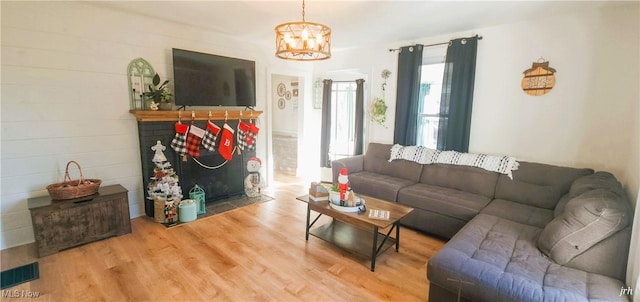 living room with a fireplace, visible vents, a chandelier, and wood finished floors