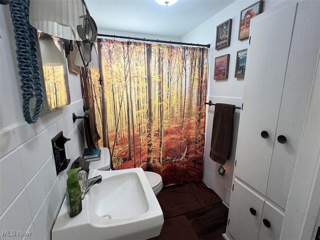 bathroom featuring hardwood / wood-style floors, toilet, sink, and tile walls