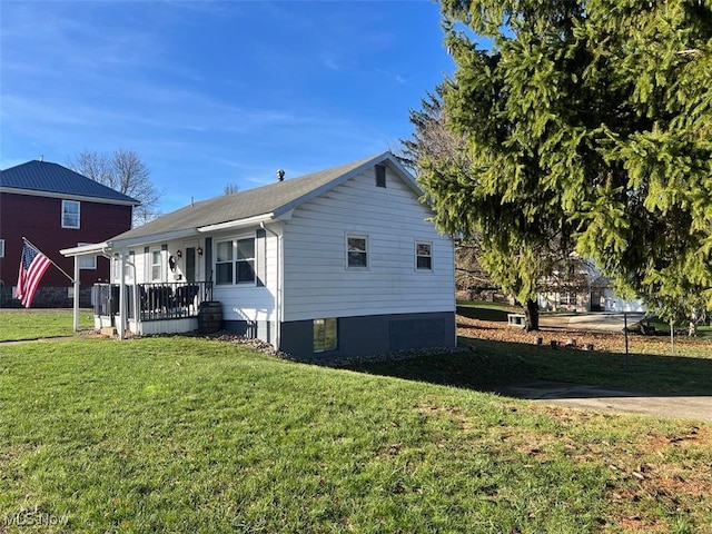 view of home's exterior with covered porch and a yard