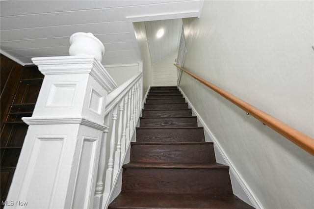 staircase featuring wood-type flooring and wood walls