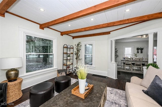 living room featuring hardwood / wood-style floors, beam ceiling, and decorative columns