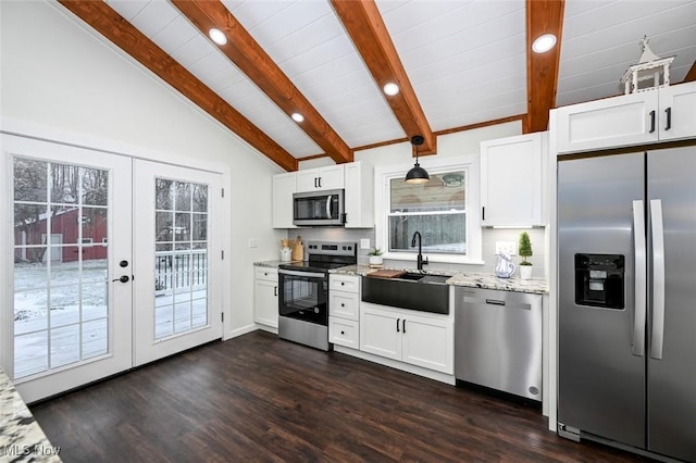 kitchen featuring lofted ceiling with beams, a wealth of natural light, stainless steel appliances, and hanging light fixtures