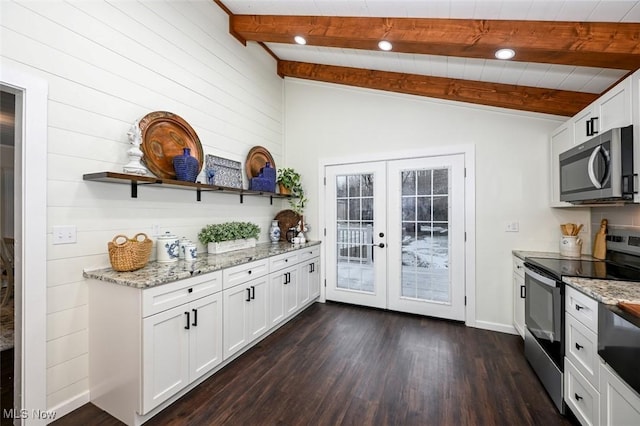 kitchen with appliances with stainless steel finishes, french doors, lofted ceiling with beams, dark hardwood / wood-style floors, and white cabinetry