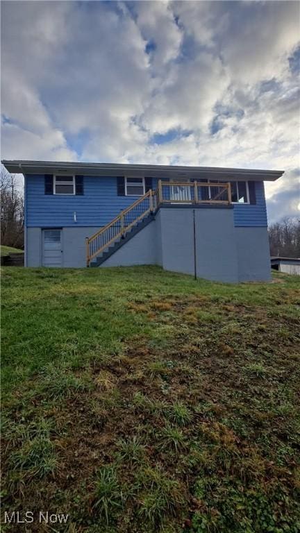 back of property with a yard and a wooden deck