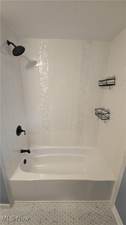 bathroom featuring tile patterned flooring and tiled shower / bath