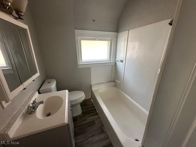 full bathroom with vanity, hardwood / wood-style flooring, plus walk in shower, toilet, and lofted ceiling