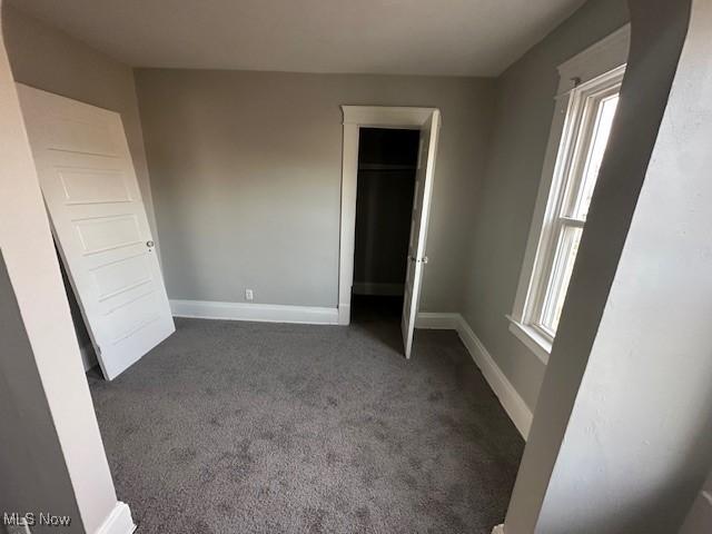 unfurnished bedroom featuring dark carpet