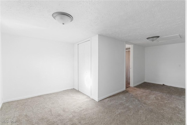 bonus room with carpet flooring and a textured ceiling