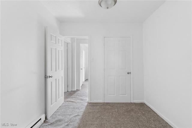 hallway featuring baseboard heating and light carpet