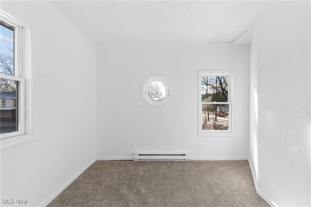 carpeted empty room with baseboard heating and a wealth of natural light