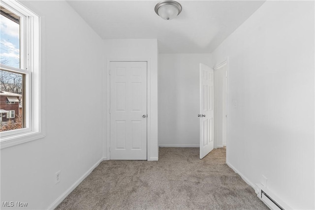 bonus room featuring light carpet, plenty of natural light, and a baseboard radiator