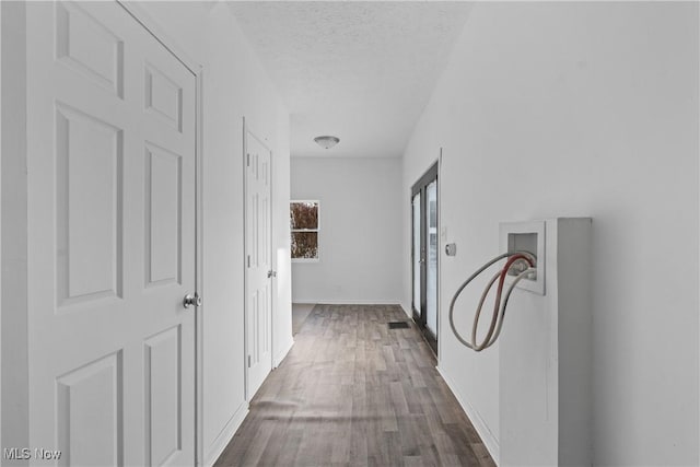 hallway with dark wood-type flooring and a textured ceiling