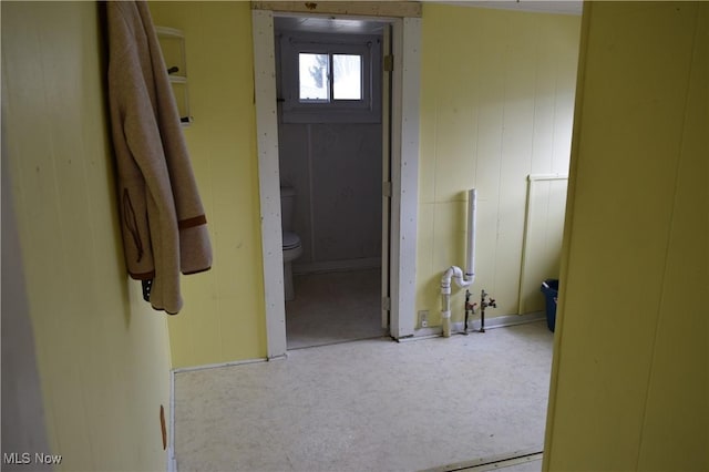 hallway featuring wooden walls