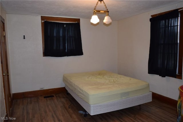 bedroom with hardwood / wood-style floors and a textured ceiling